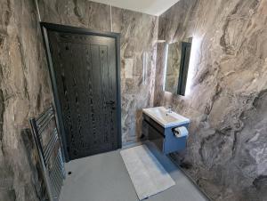 a bathroom with a black door and a sink at Wee Catriona in Brodick