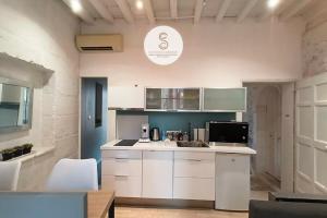 a kitchen with white cabinets and a sink at Côté Calade Arles Centre in Arles