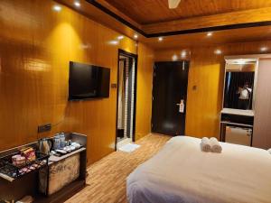 a hotel room with a bed and a flat screen tv at TUPTUP Resto & Resort in Ināni