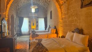 a bedroom with two beds in a large room at Alies Konağı in Mardin