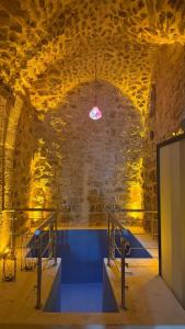 a room with a stone wall and a pink light at Alies Konağı in Mardin