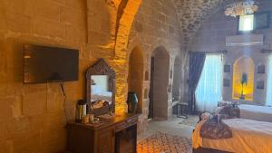 a bedroom with a bed and a tv on a wall at Alies Konağı in Mardin +4 photos