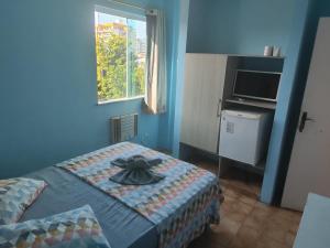 a bedroom with a bed with a hat on it at Hotel Nanuque in Cabo Frio