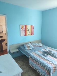 a bedroom with two beds and a blue wall at Hotel Nanuque in Cabo Frio