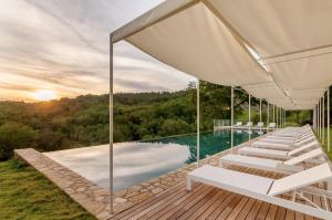 a house with a pool and a deck with lounge chairs at Borgo Casa al Vento in Gaiole in Chianti