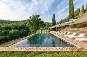 a swimming pool with lounge chairs and a swimming poolvisor at Borgo Casa al Vento in Gaiole in Chianti