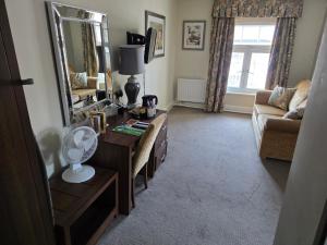a living room with a table and a mirror at The Royal Oak Hotel, Welshpool - The Coaching Inn Group in Welshpool