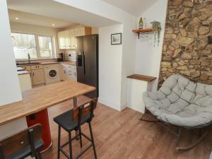 a kitchen with a table and chairs and a stone wall at 41 St James Street in Narberth