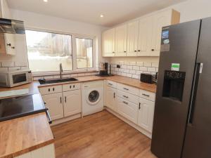 a kitchen with white cabinets and a stainless steel refrigerator at 41 St James Street in Narberth +10 photos