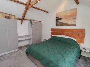 a bedroom with a green comforter on a bed at 41 St James Street in Narberth