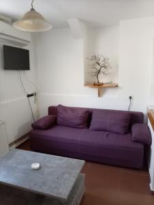 a purple couch in a living room with a table at Dana in Trnava