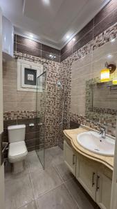 a bathroom with a toilet and a sink and a shower at Rosaio in El Alamein