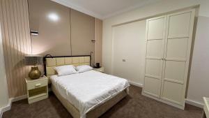 a bedroom with a white bed and a closet at Rosaio in El Alamein