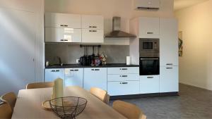 a kitchen with white cabinets and a table in it at Vista Duomo Foligno in Foligno