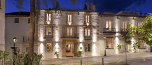 a large white building with lights on it at La Fonda Heritage Hotel Luxury, Relais & Châteaux in Marbella