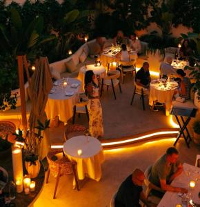 a group of people sitting at tables in a restaurant at night at La Fonda Heritage Hotel Luxury, Relais & Châteaux in Marbella