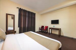 a hotel room with a bed and a desk and a television at The Prakriti Retreat l Pure Veg l Lift l Indoor Multi Cuisine Restaurant l Power Backup Available l Managed By ExoticStays Group in Kūfrī