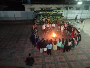 a group of people standing around a fire at HOLIDAY HOMEs MALPE in Udupi
