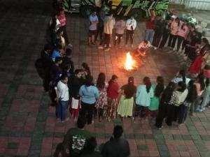 a group of people standing around a fire at HOLIDAY HOMEs MALPE in Udupi