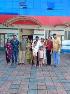 a group of people posing for a picture in front of a building at HOLIDAY HOMEs MALPE in Udupi