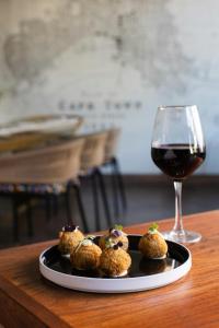 a plate of food and a glass of wine at ONOMO Hotel Cape Town – Inn On The Square in Cape Town +86 photos