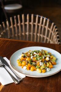 a white plate of food on a wooden table at ONOMO Hotel Cape Town – Inn On The Square in Cape Town