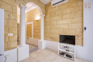 a living room with a fireplace and a tv at Luqa Stone Maisonette Apartments Near Airport in Luqa +37 photos