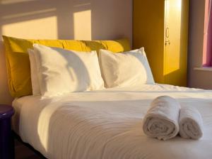 a white bed with two towels on top of it at Zozy Clitterhouse in London