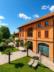 a large orange building with palm trees in front of it at Baco Da Seta Residence con Piscina - Venezia Mestre in Mestre