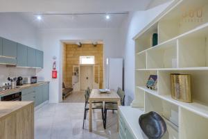 a kitchen and dining room with a table and chairs at Luqa Stone Maisonette Apartments Near Airport in Luqa