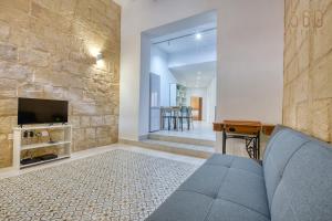 a living room with a couch and a tv at Luqa Stone Maisonette Apartments Near Airport in Luqa