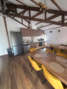 a large dining room with a table and yellow chairs at Къща за гости Старлес in Malko Tŭrnovo +26 photos