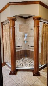 a bathroom with a shower with two wooden columns at North River Inn in Bridgewater +74 photos