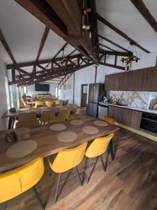 a large dining room with a large wooden table and yellow chairs at Къща за гости Старлес in Malko Tŭrnovo