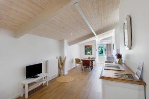 a living room with a television and a dining room at Chambre d'hôtes Château Austerlitz in Libourne