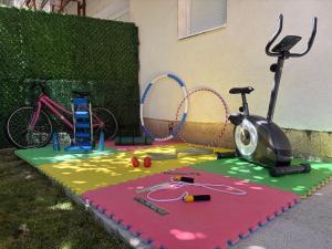 a playground with a treadmill and a bike on the grass at Apartments Ratkovic in Trebinje