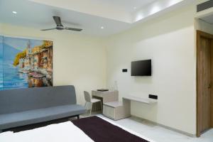 a living room with a couch and a tv at Dwarka Palace in Hingoli +13 photos