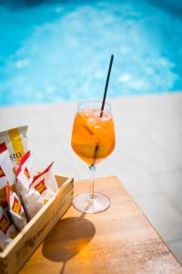 a drink in a glass on a table near a pool at Masseria Marotta in Santa Paolina