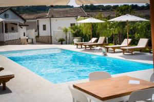 a pool with chairs and tables and umbrellas at Masseria Marotta in Santa Paolina