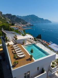 an aerial view of a building with a swimming pool and the ocean at Il Tipografo di Amalfi A Family Museum Hotel in Amalfi