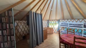 a room with a table and a bed in a yurt at Yourtes insolites in Querrien
