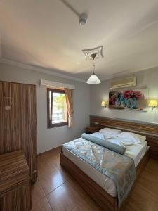 a bedroom with a bed and a window at Ozukara Apart 1 in Gümbet +99 photos