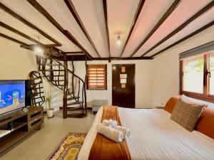 a bedroom with a large bed with a tv at Galera Lodge & Cafe in Puerto Galera