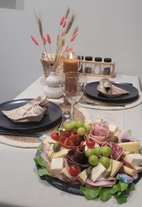 a table with two plates of food and a plate of cheese at Le Chalet romantique avec jacuzzi privatif in Lirac