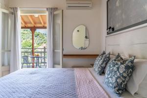 a bedroom with a bed with blue and white pillows at Flower in Skiathos
