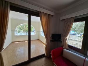 a living room with glass doors and a red couch at Ozukara Apart 1 in Gümbet