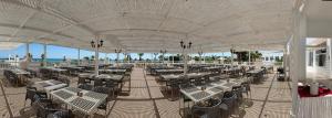 an empty patio with tables and chairs on the beach at Caribbean World Mahdia in Mahdia