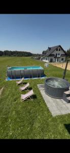 a group of benches and a pool in a field at Domki pod Lasem 66 in Trybsz
