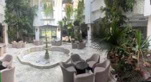 a lobby with a fountain and chairs and plants at Caribbean World Mahdia in Mahdia +12 photos