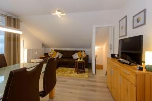 a living room with a couch and a television at Feriendorf Schwarzholz in Viechtach